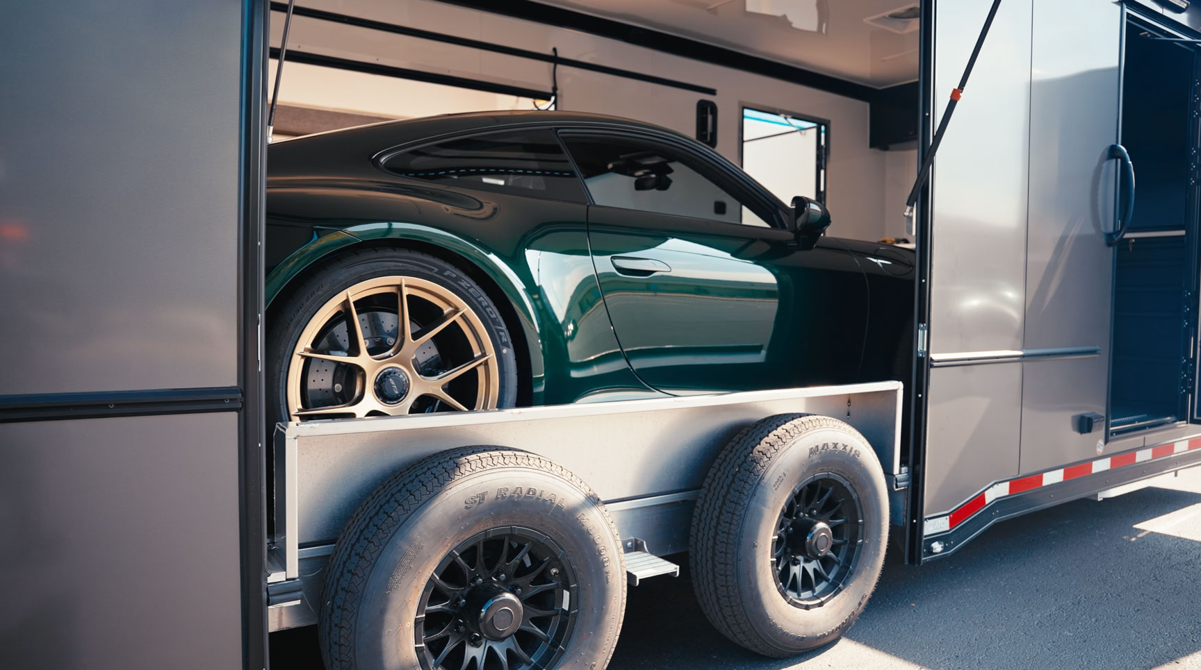 Porsche 911 loaded into fully-enclosed transport trailer to receive PPF protected from the elements.