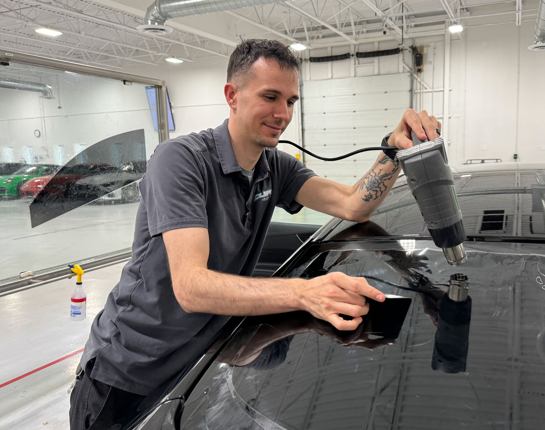 Installer appling Xpel window film car tint.